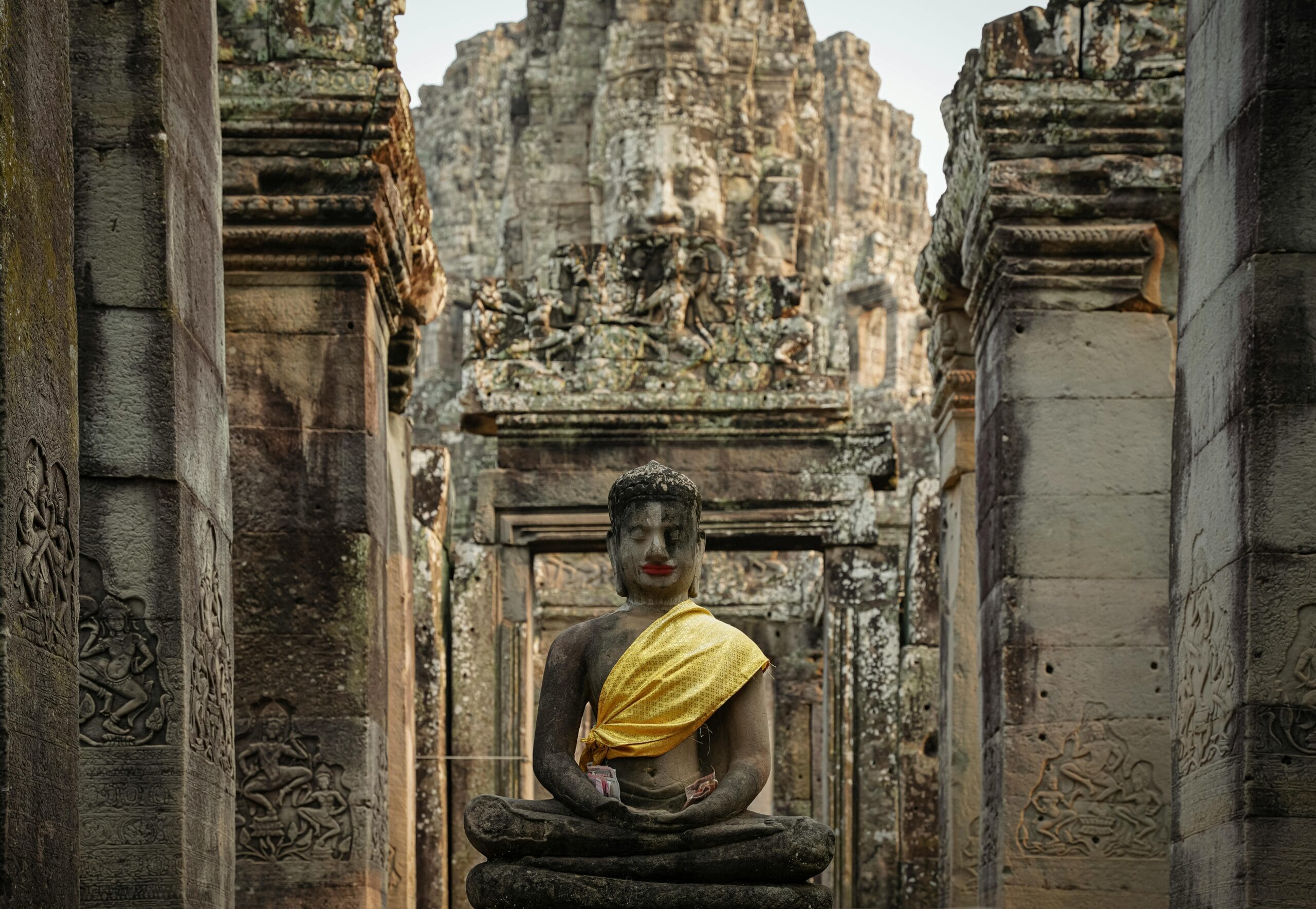 Majestic Buddha statue draped in yellow cloth at Bayon Temple, Cambodia.